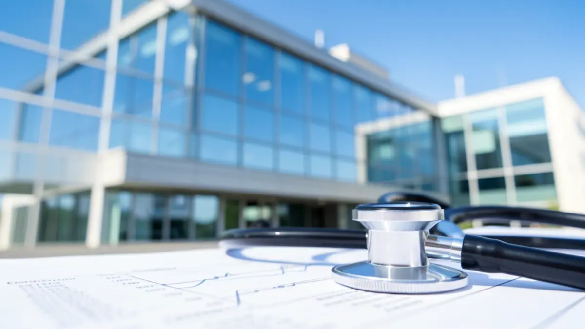 Modern hospital building with a stethoscope on a medical chart, representing healthcare innovation and patient care.